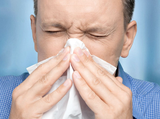 Hombre estornudando por alergias
